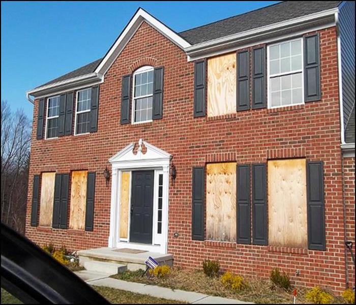 brick home with windows boarded up