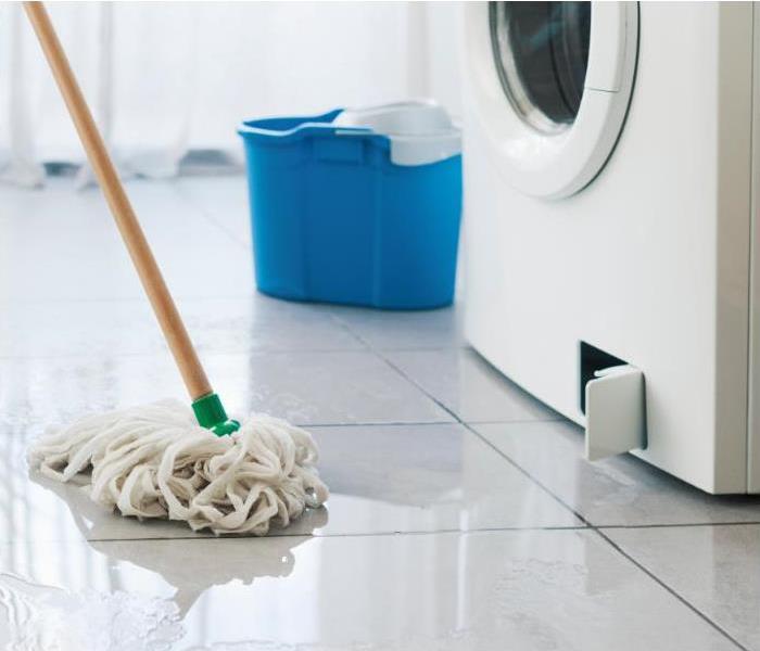 Broken washing machine leaking on the floor